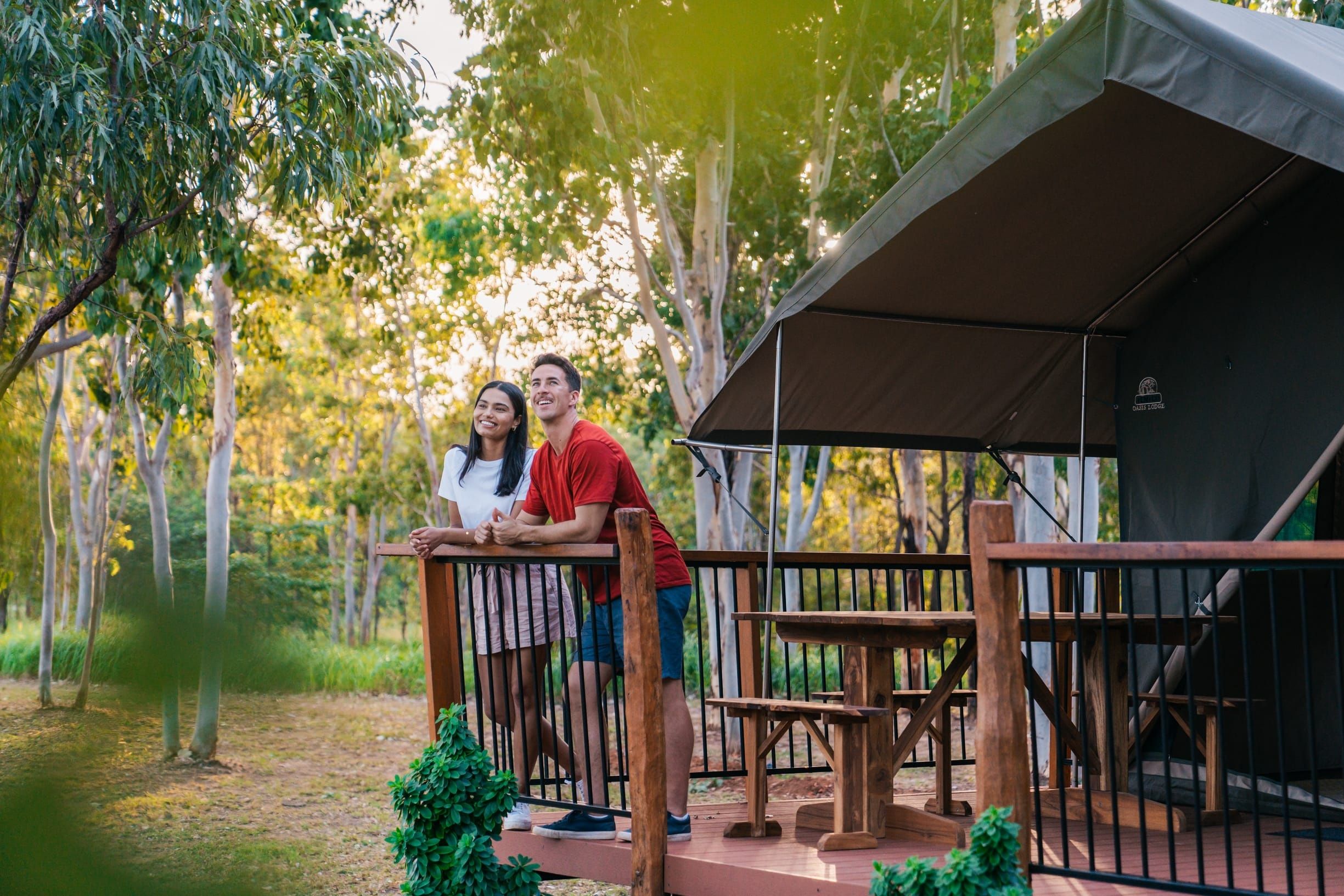 Couple relax on the deck of their glamping tent at Rossville Retreat, surrounded by bushland