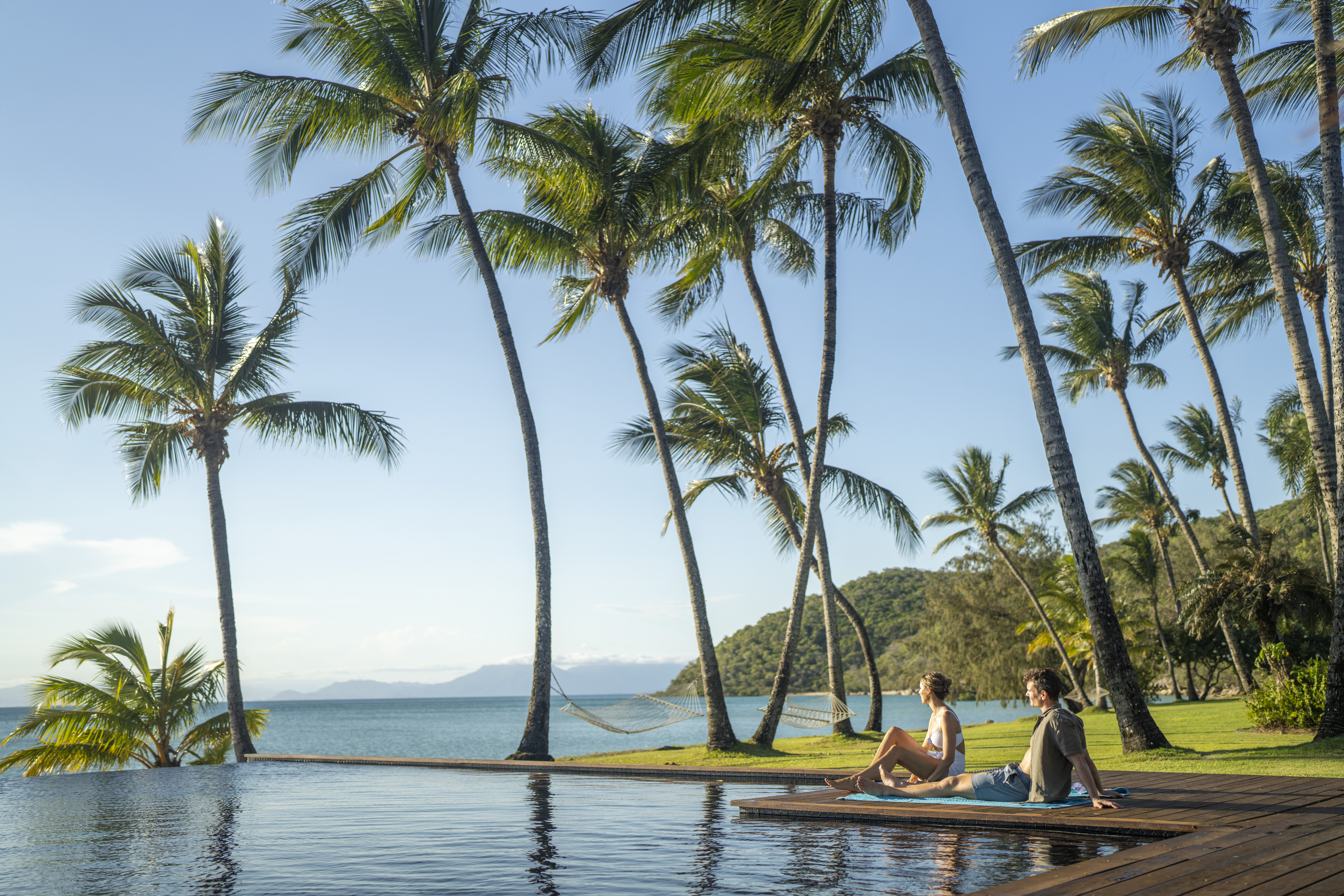 Couple relaxing beside the resort pool at Orpheus Island