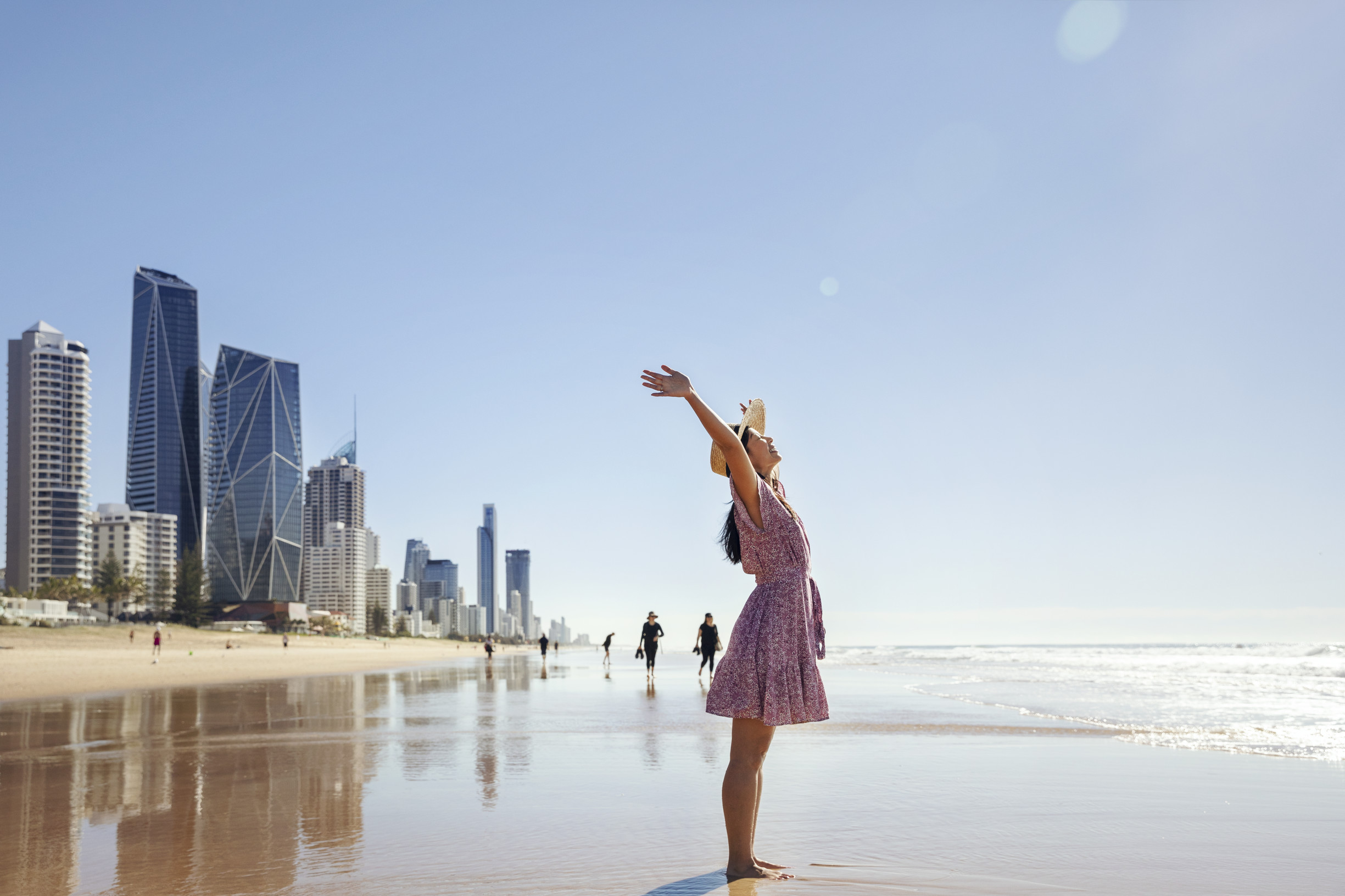 Lady standing on the beach in front of the Surfers Paradise skyline