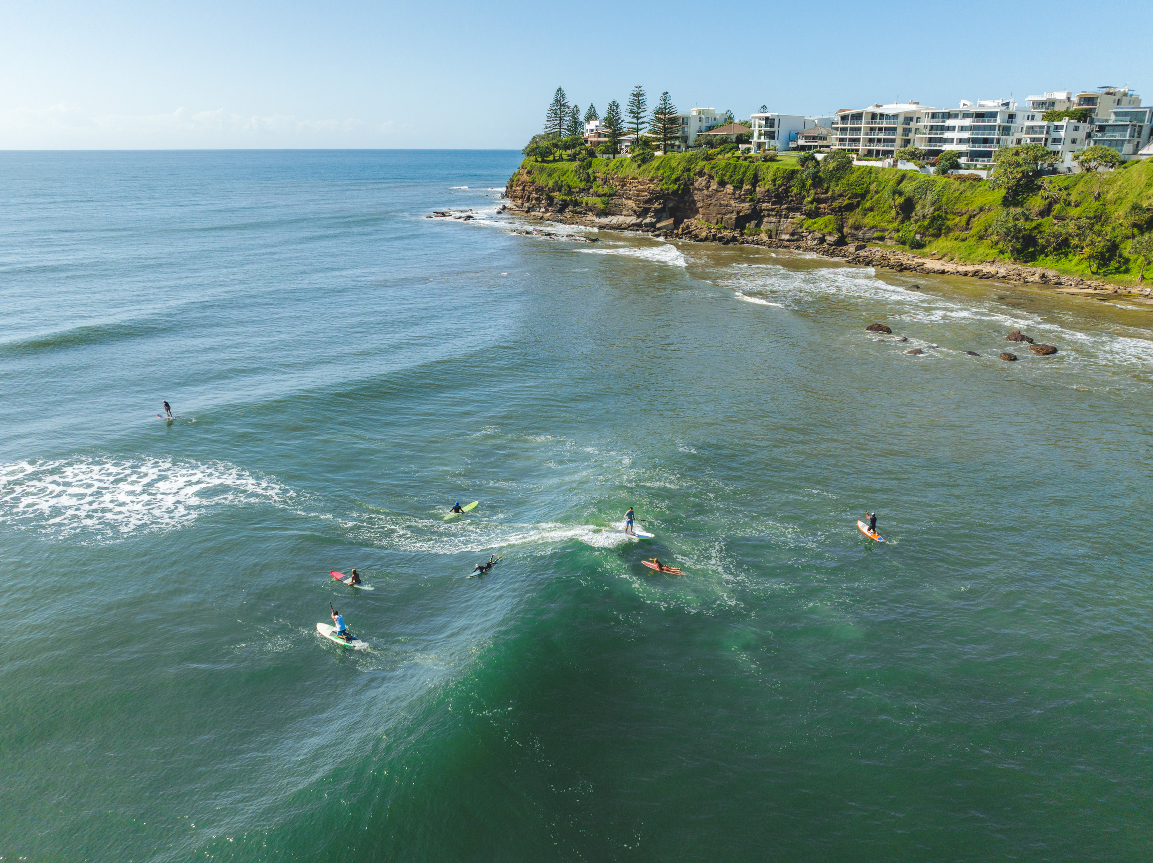 Aerial view of people surfing at Moffat Beach Aerial view of people surfing at Moffat Beach